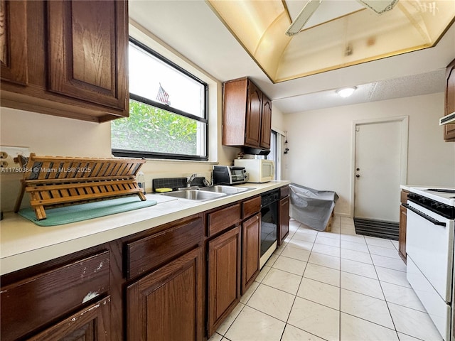 kitchen with a sink, light countertops, light tile patterned flooring, a toaster, and white appliances
