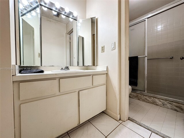 bathroom featuring toilet, vanity, and a shower stall
