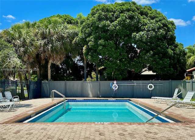 view of swimming pool featuring fence, a patio area, and a swimming pool