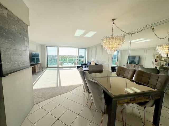 dining area with an inviting chandelier, a decorative wall, a wall of windows, and light colored carpet