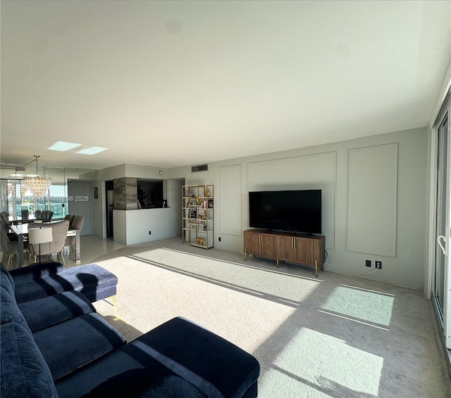 living room with light carpet, visible vents, and a decorative wall