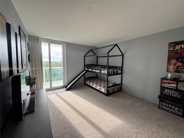 bedroom with expansive windows, access to outside, and light colored carpet