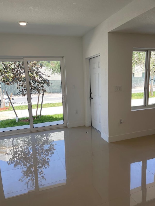 doorway featuring light tile patterned floors, baseboards, and recessed lighting