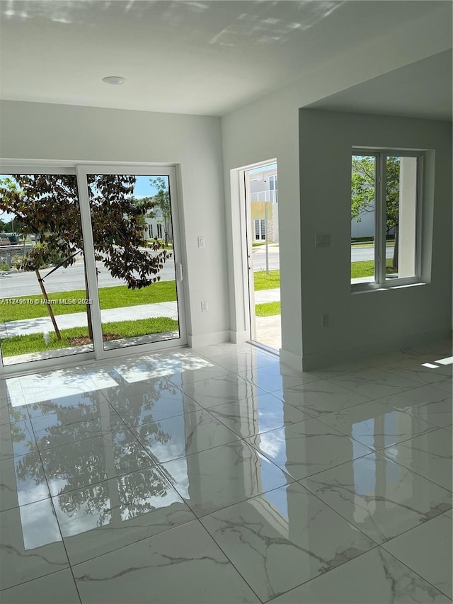 doorway to outside with marble finish floor