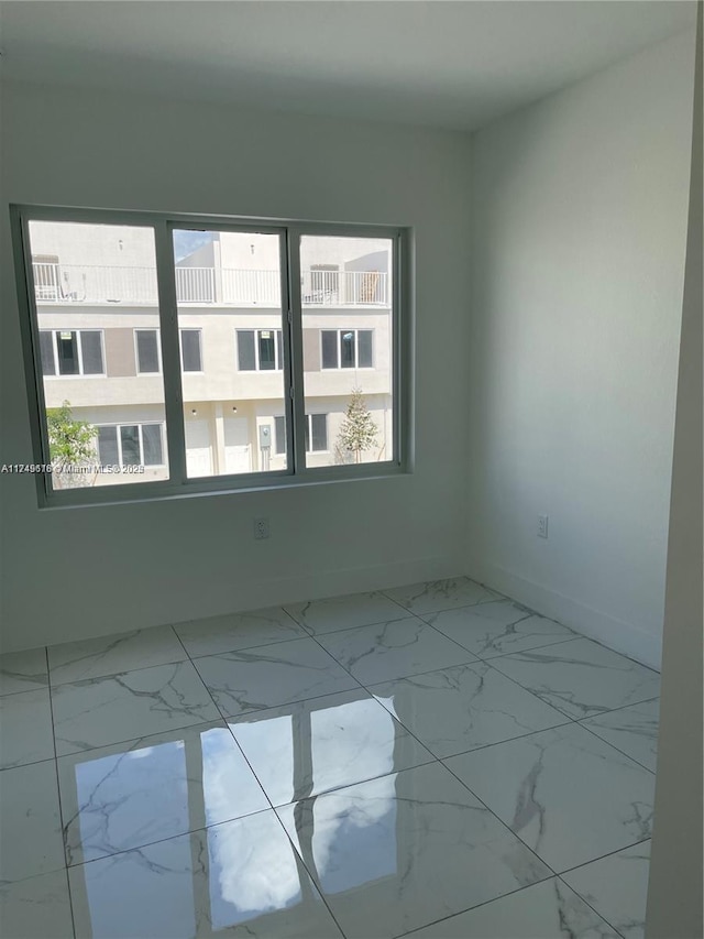 unfurnished room with marble finish floor