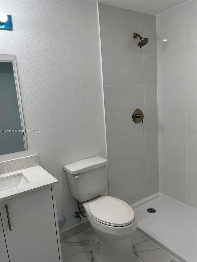 bathroom with a stall shower, marble finish floor, vanity, and toilet