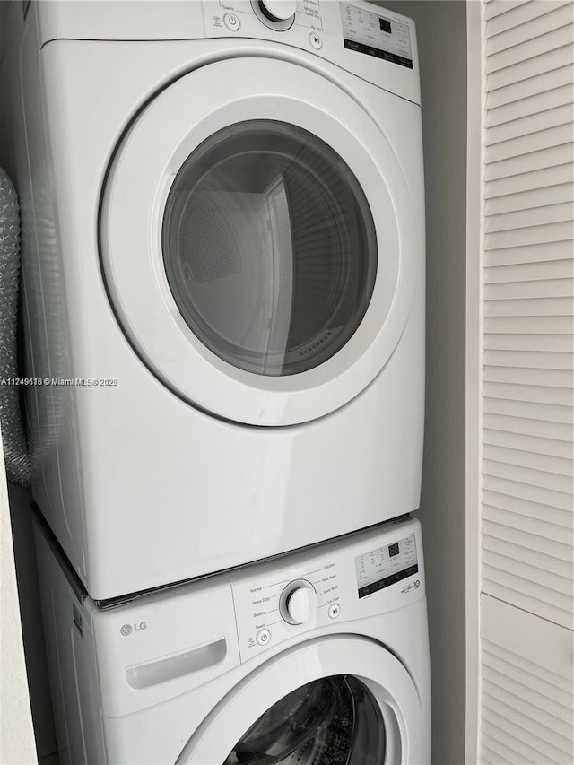 washroom featuring stacked washer and dryer and laundry area