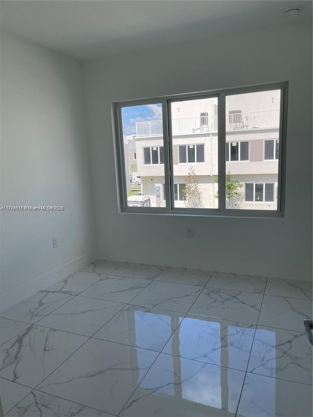 unfurnished room with marble finish floor