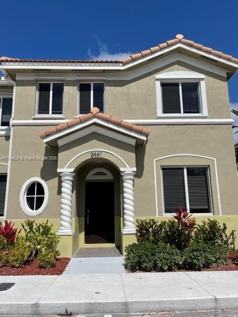 view of front of house with a tile roof and stucco siding