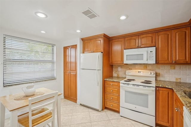 900 Colony Point Cir Unit 408, Pembroke Pines, FL 33026 - kitchen with white appliances, light stone countertops, brown cabinetry, decorative backsplash, and recessed lighting
