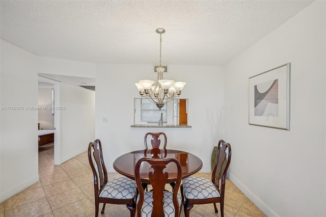 dining area featuring baseboards, a chandelier, a textured ceiling, and light tile patterned flooring