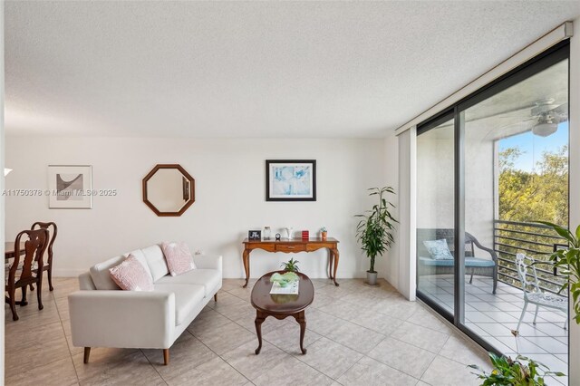 living room with a textured ceiling, light tile patterned floors, and a wall of windows