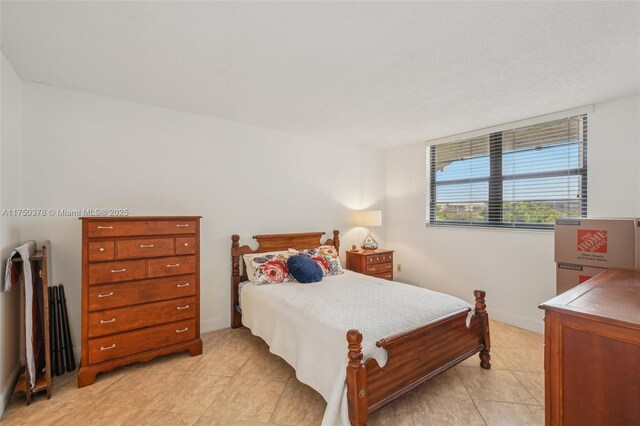 bedroom with light tile patterned floors and baseboards