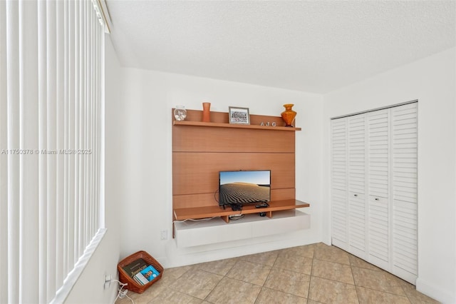 unfurnished office featuring a textured ceiling and light tile patterned floors