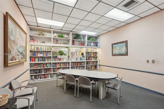 office featuring bookshelves, carpet flooring, visible vents, and built in features