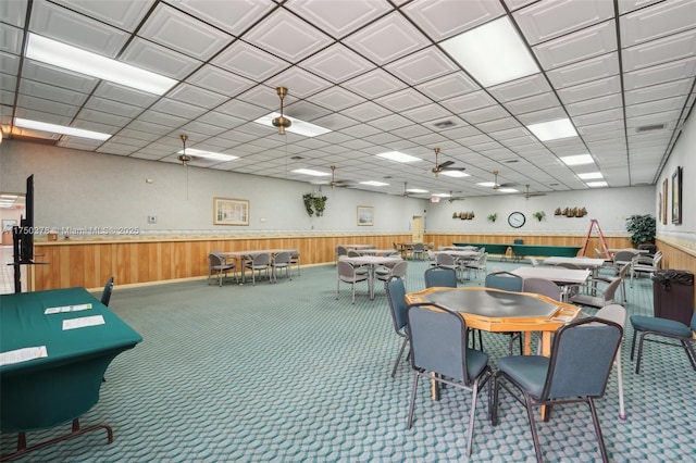 interior space with a wainscoted wall, wood walls, and carpet flooring