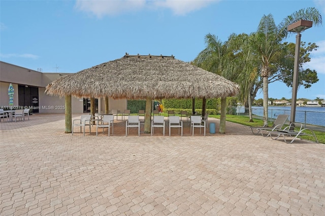 view of home's community with a gazebo, a water view, and fence