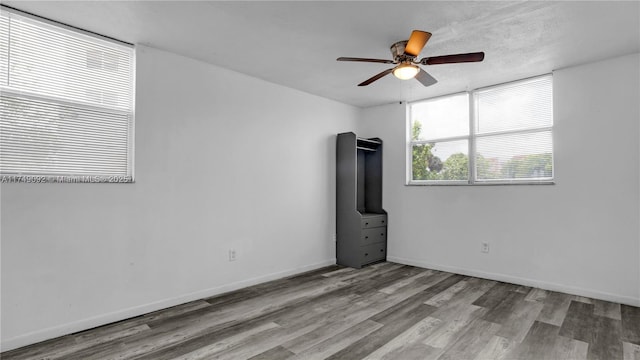 empty room featuring light wood-type flooring, ceiling fan, and baseboards