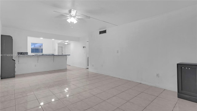 unfurnished living room with a ceiling fan, visible vents, and light tile patterned flooring