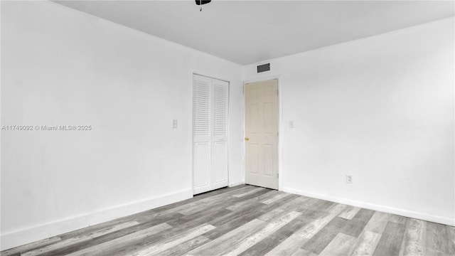 empty room featuring light wood-style floors and baseboards