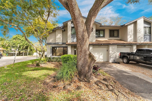 view of front of property featuring driveway, an attached garage, and stucco siding