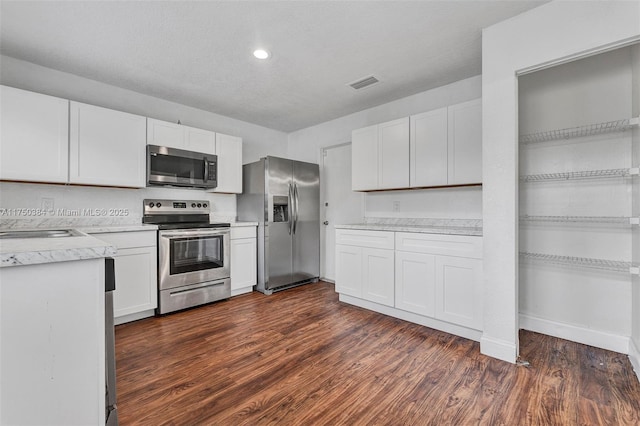 kitchen with visible vents, stainless steel appliances, light countertops, and white cabinetry