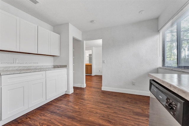 kitchen featuring dark wood-style floors, white cabinetry, baseboards, light countertops, and dishwasher