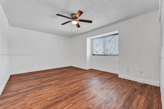 empty room with dark wood-type flooring, a textured ceiling, baseboards, and a ceiling fan