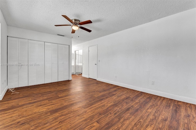 unfurnished bedroom featuring a textured ceiling, dark wood-type flooring, and visible vents