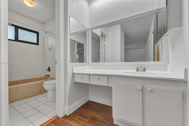 full bathroom featuring shower / bath combination, toilet, wood finished floors, a textured ceiling, and vanity