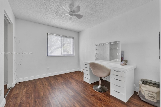 home office with a ceiling fan, dark wood-style flooring, a textured ceiling, and baseboards