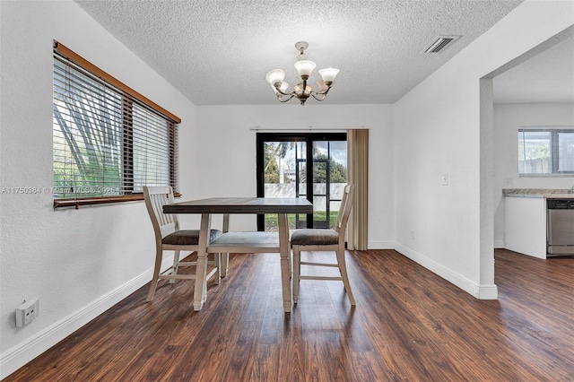 dining space with plenty of natural light, dark wood finished floors, visible vents, and a notable chandelier