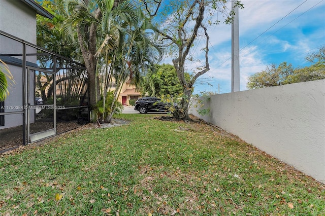 view of yard with a lanai and fence