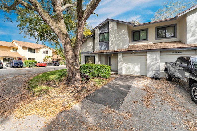 townhome / multi-family property featuring a garage, driveway, and stucco siding