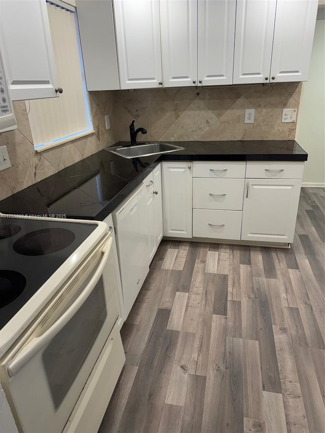 kitchen featuring white appliances, tasteful backsplash, dark wood finished floors, white cabinetry, and a sink