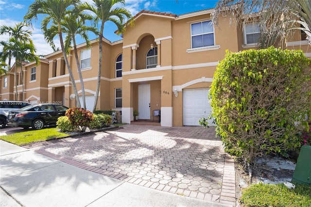 view of property with a garage and stucco siding