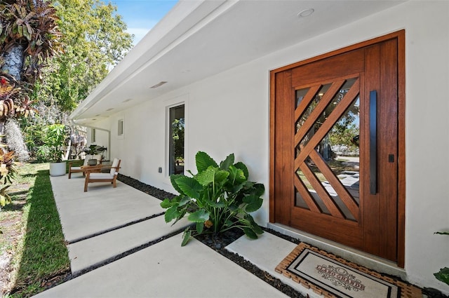 entrance to property with a patio area and stucco siding