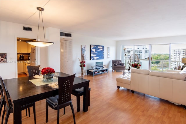 dining area with visible vents and wood finished floors