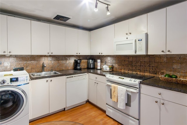 kitchen featuring washer / clothes dryer, visible vents, white cabinets, a sink, and white appliances