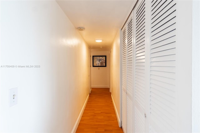 hallway with light wood-style floors and baseboards