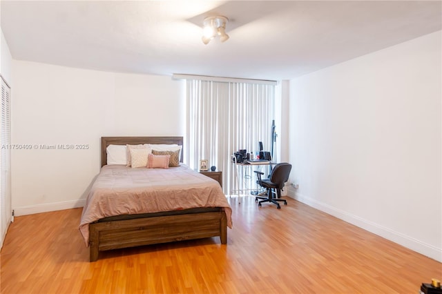 bedroom with baseboards and wood finished floors