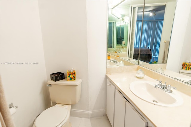 bathroom featuring baseboards, vanity, toilet, and tile patterned floors