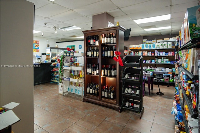 interior space with a drop ceiling and tile patterned floors