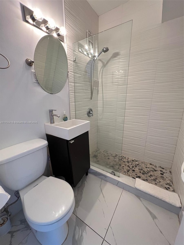 bathroom with marble finish floor, walk in shower, and vanity