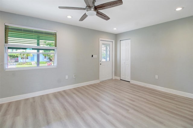 empty room featuring light wood-type flooring, baseboards, and recessed lighting