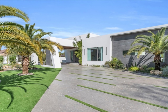 property entrance featuring a yard and stucco siding