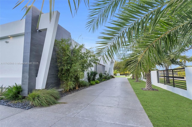 view of property's community with fence and a lawn