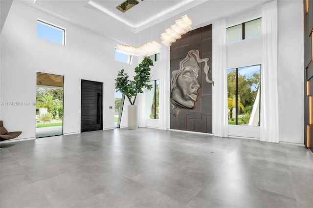 interior space featuring finished concrete floors, plenty of natural light, and a towering ceiling