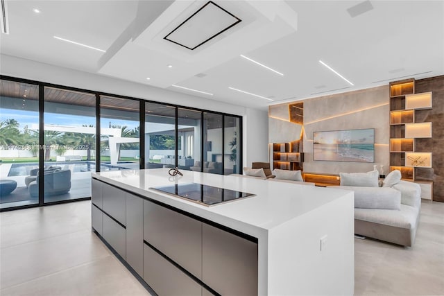 kitchen with modern cabinets, open floor plan, a kitchen island, and black electric cooktop