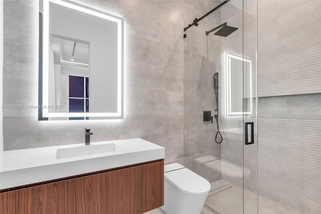 bathroom featuring toilet, a shower stall, vanity, and tile walls